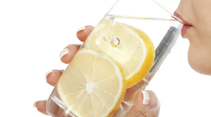 женщина пьет лимонную воду маленькими глотками